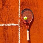 tennis ball on tennis racket on floor